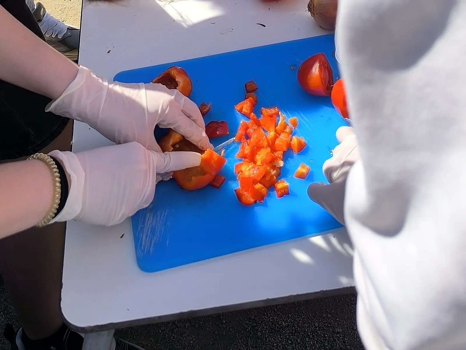 Manos cortando pimiento rojo para el sofrito en una actividad de paellas en Tarragona