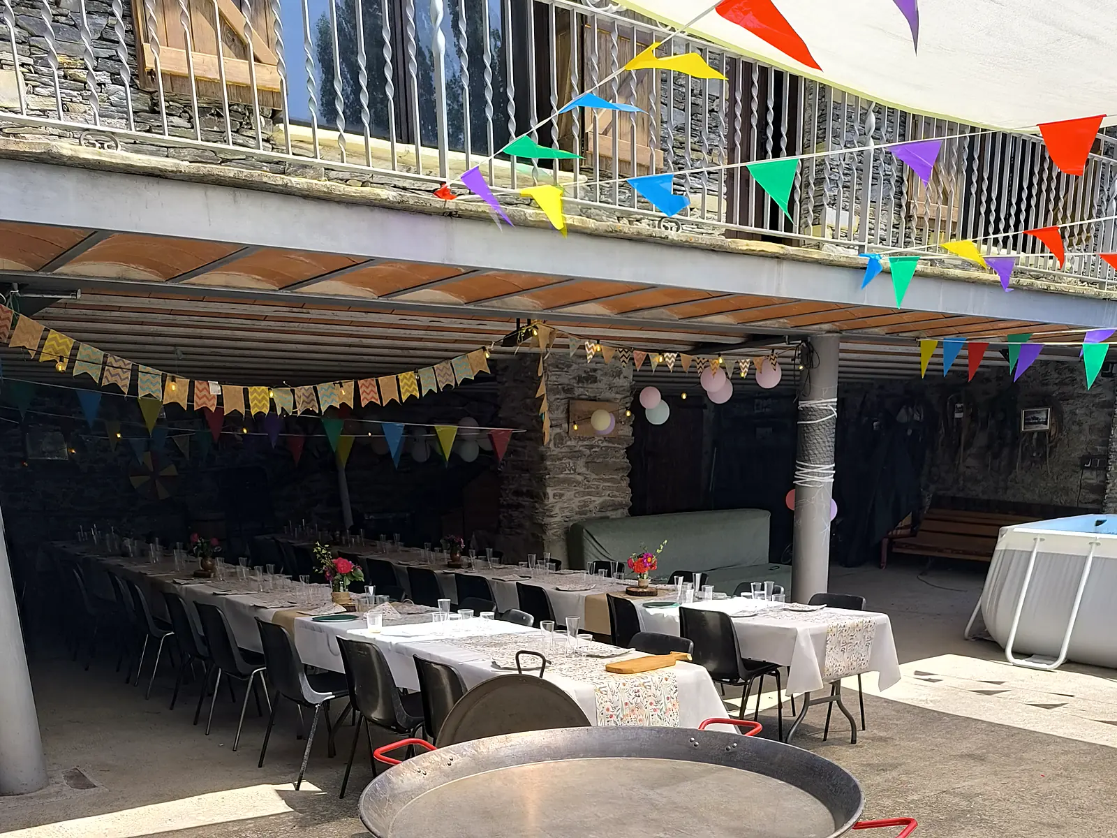 Espacio preparado con mesas largas y paellera para un evento en el Pirineo de Lleida
