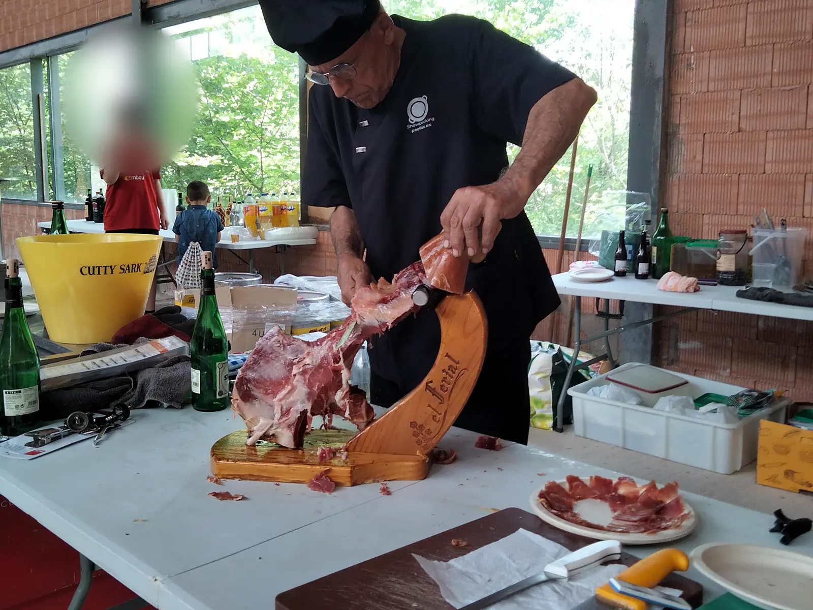 El maestro paellero Enric Fort cortando jamón en un evento en Teruel