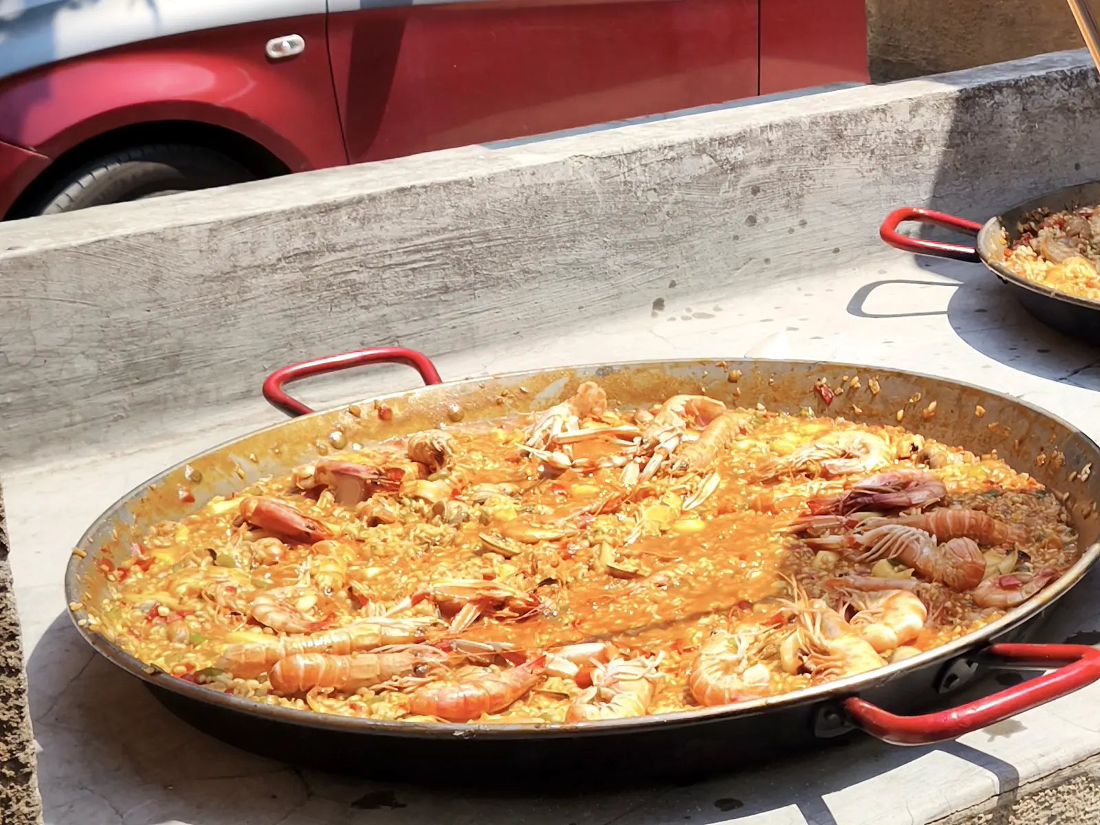 Paella de marisco terminada sobre una parrilla de obra en Reus