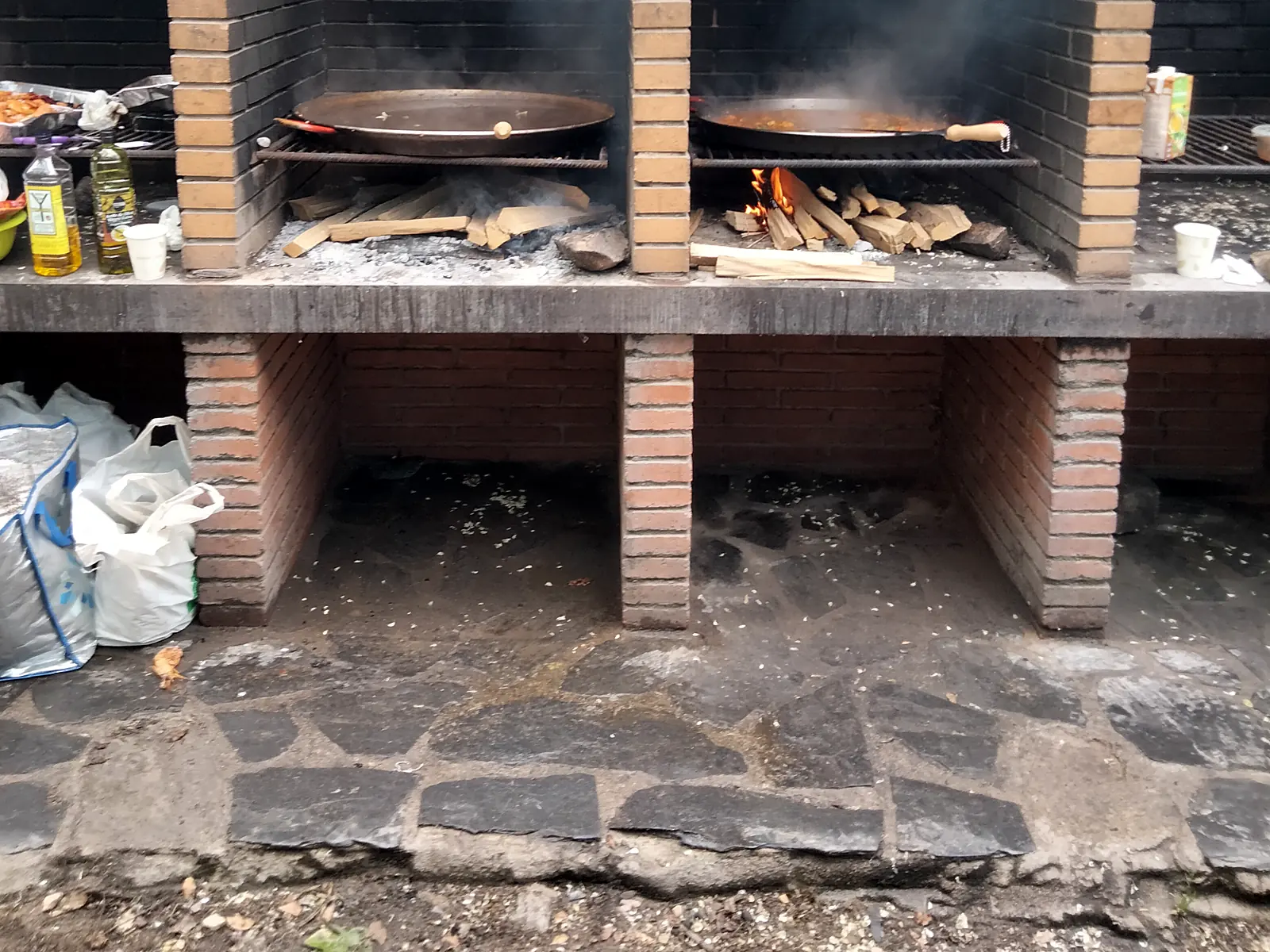 Parrillas de obra con paellas al fuego de leña