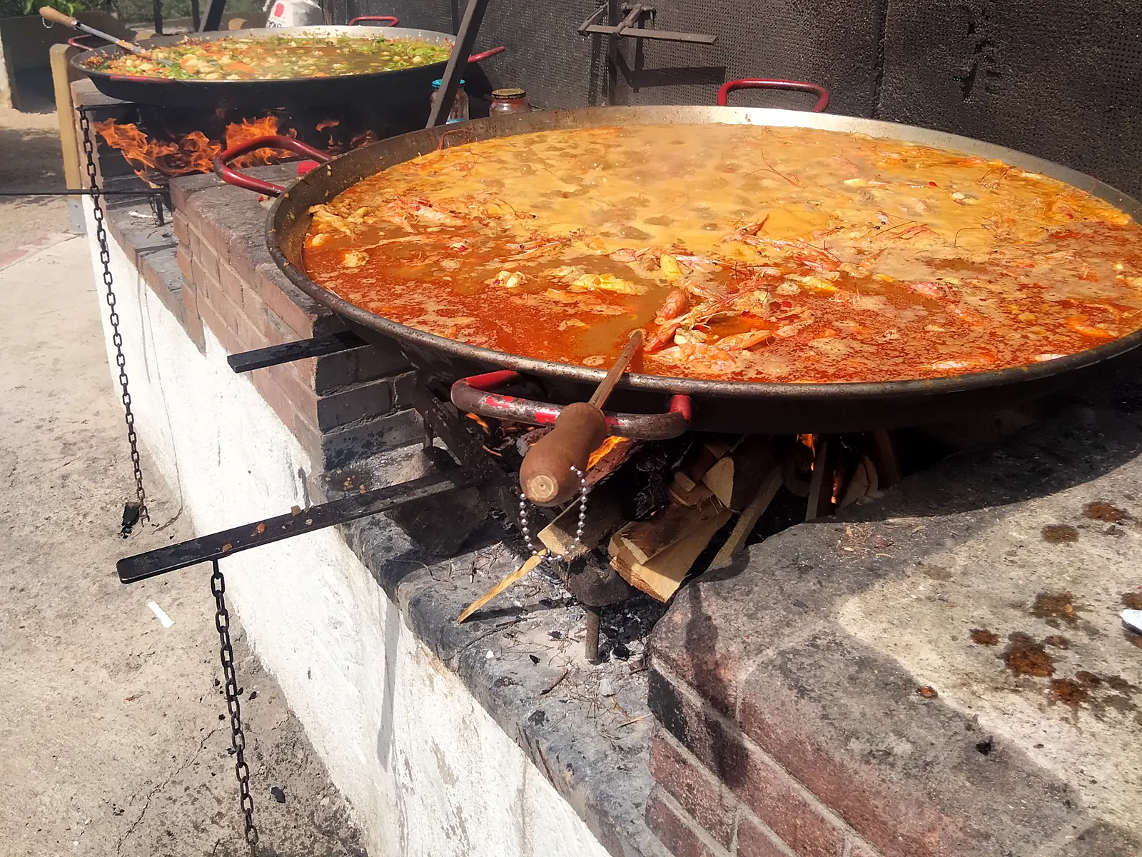 Paellas cocinándose a la leña en una parrilla de obra durante un team building